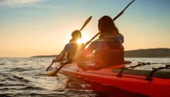 Kayaker rowing in sea